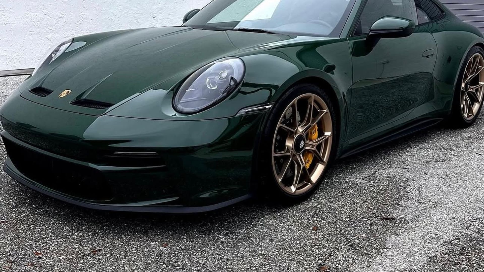 Dark green Porsche 911 with gold wheels